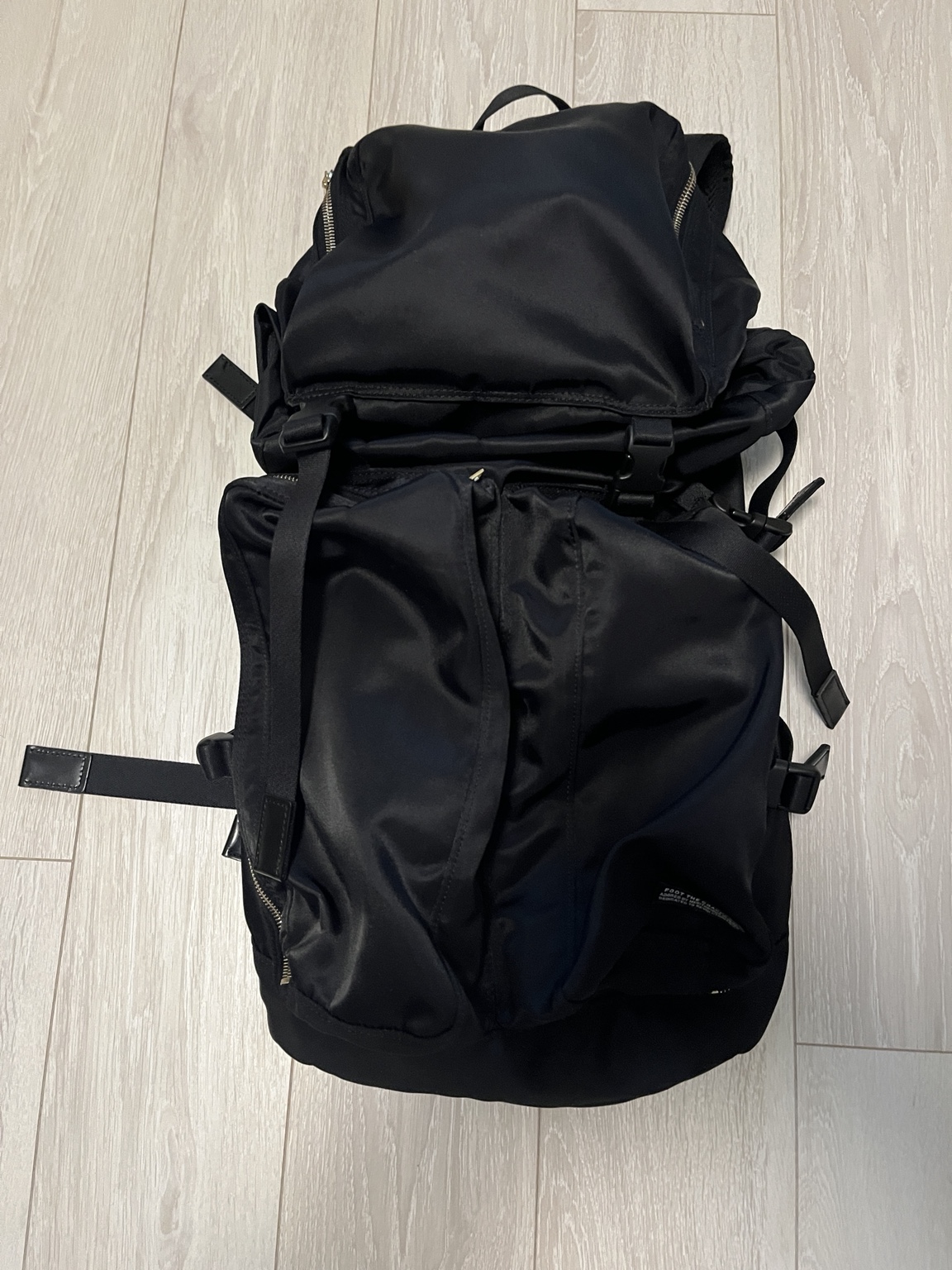 約3年使ったPORTER × foot the coacherの黒バックパック。フラップと立体的なフロントポケット、ストラップが見える。